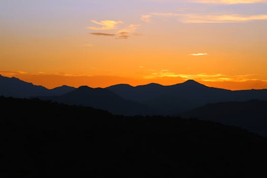 Silhouette of a mountain range during a breathtaking sunset with vibrant colors.