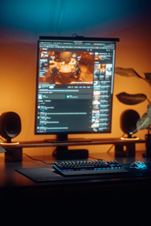 Modern Home Office Computer Setup with Ambient Lighting · Free Stock Photo