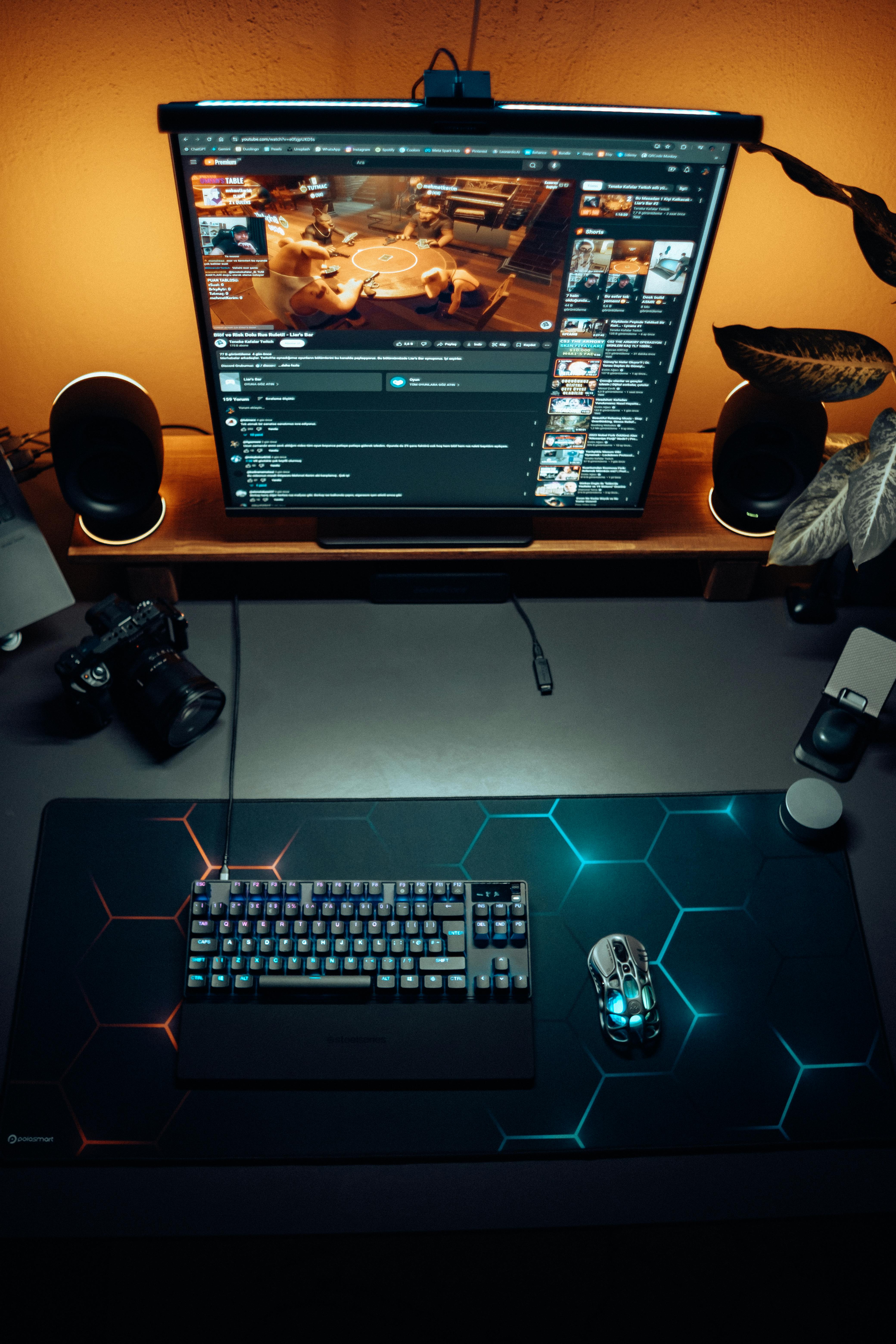Sleek gaming desk setup featuring RGB keyboard and mouse under ambient lighting.