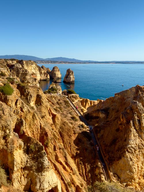 Free Explore the breathtaking orange cliffs and clear blue waters of Algarve's coast in Portugal. Stock Photo