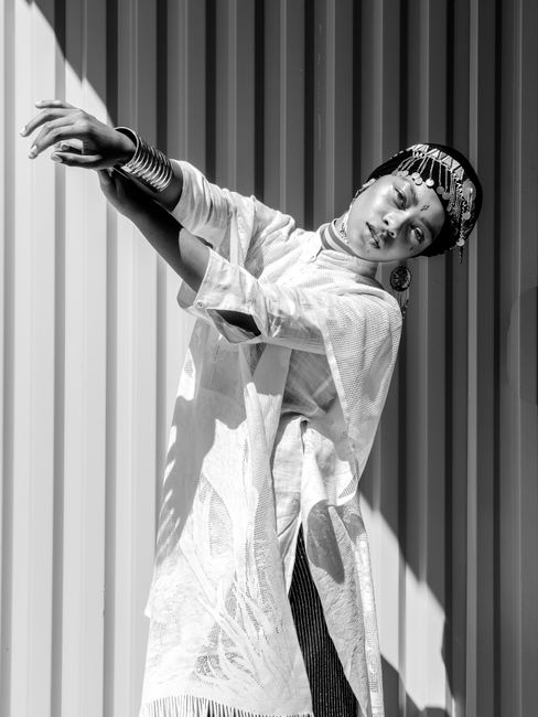 Striking monochrome portrait of a stylish woman posing outdoors with unique attire