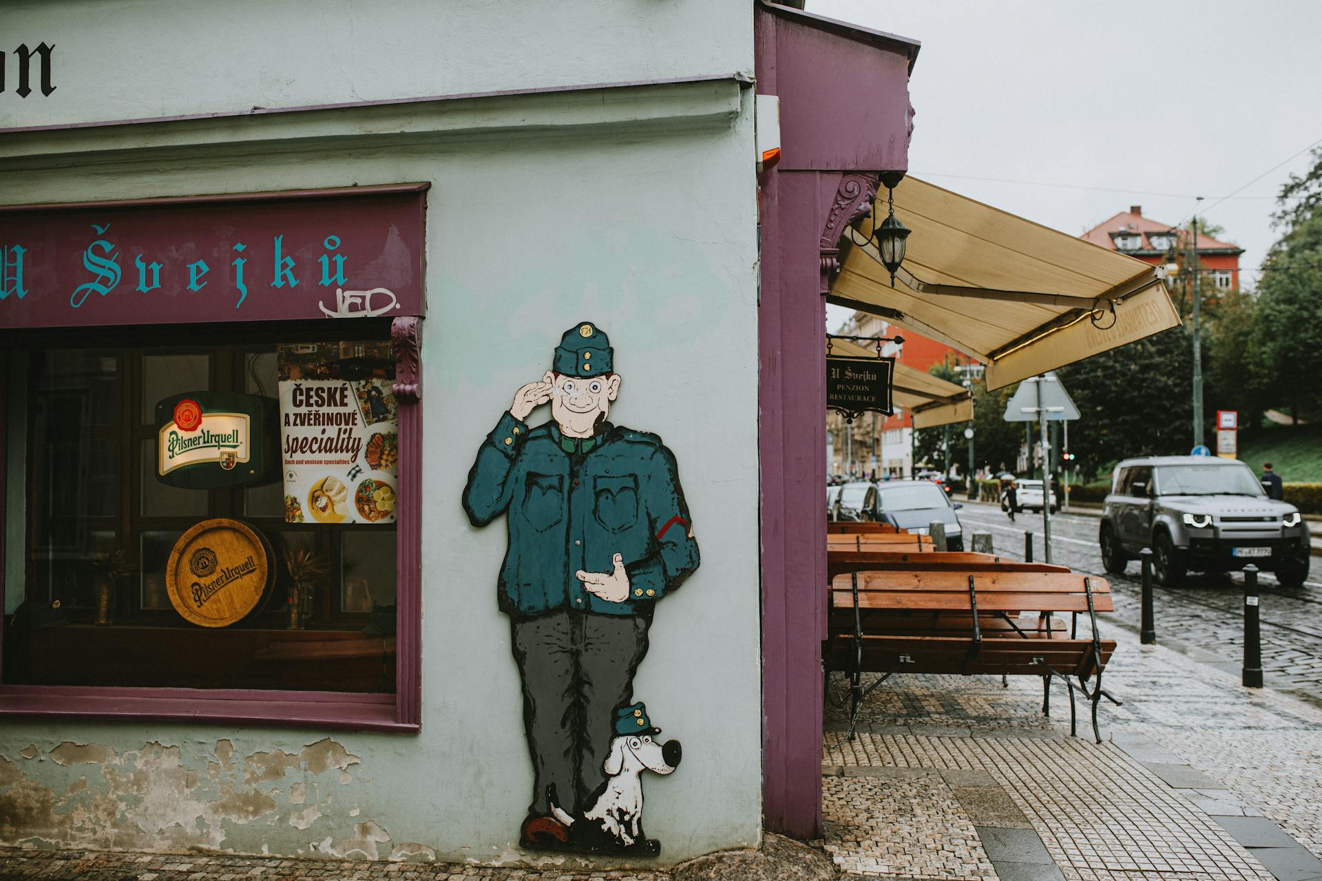 Street art of a soldier and dog outside U Švejků restaurant in Prague.