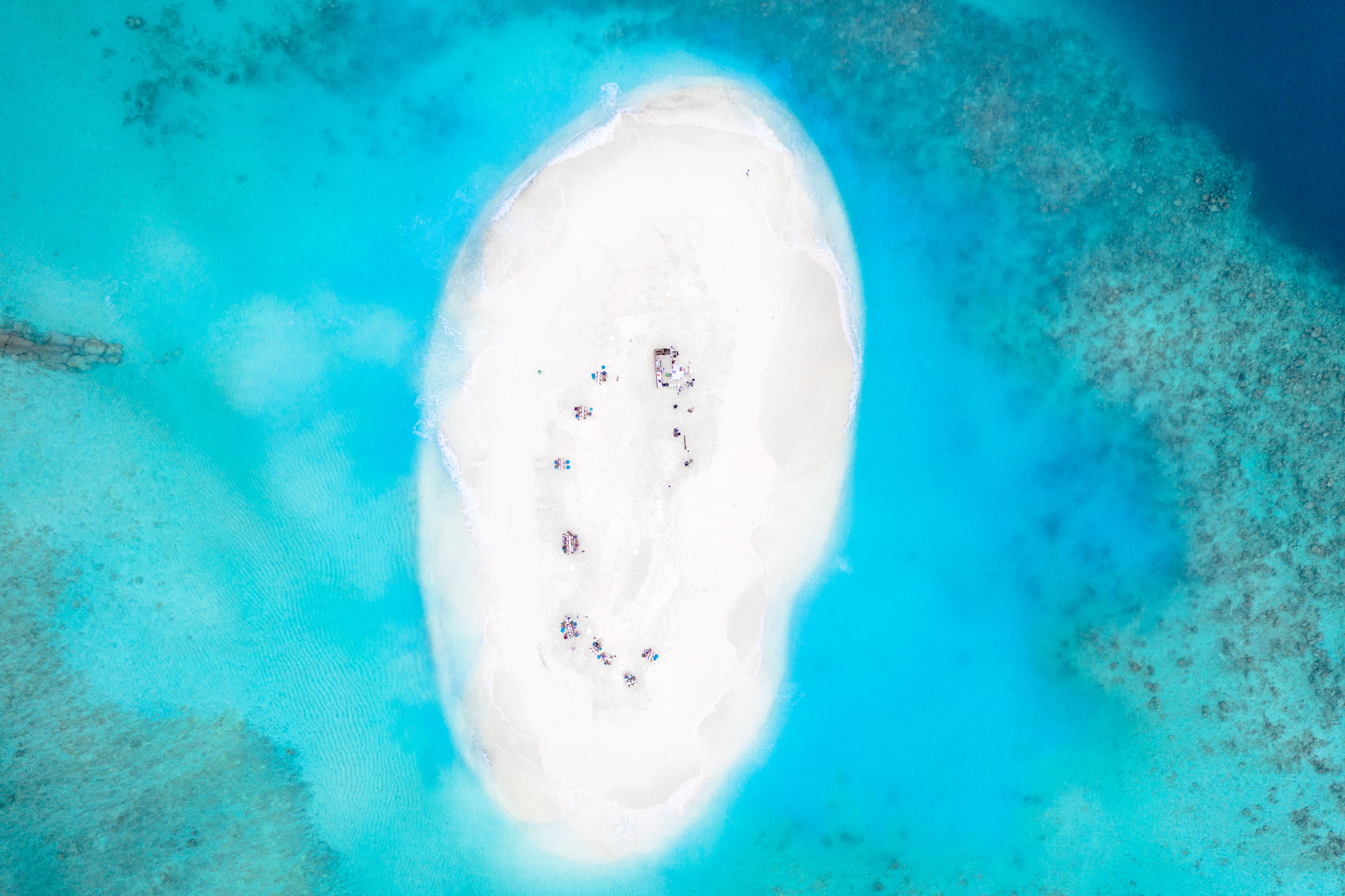 Stunning aerial view of a secluded tropical island surrounded by turquoise waters in the Maldives.