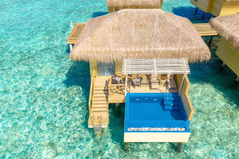 モルディブにあるプライベートプール付きの静かな水上バンガローの空中写真。