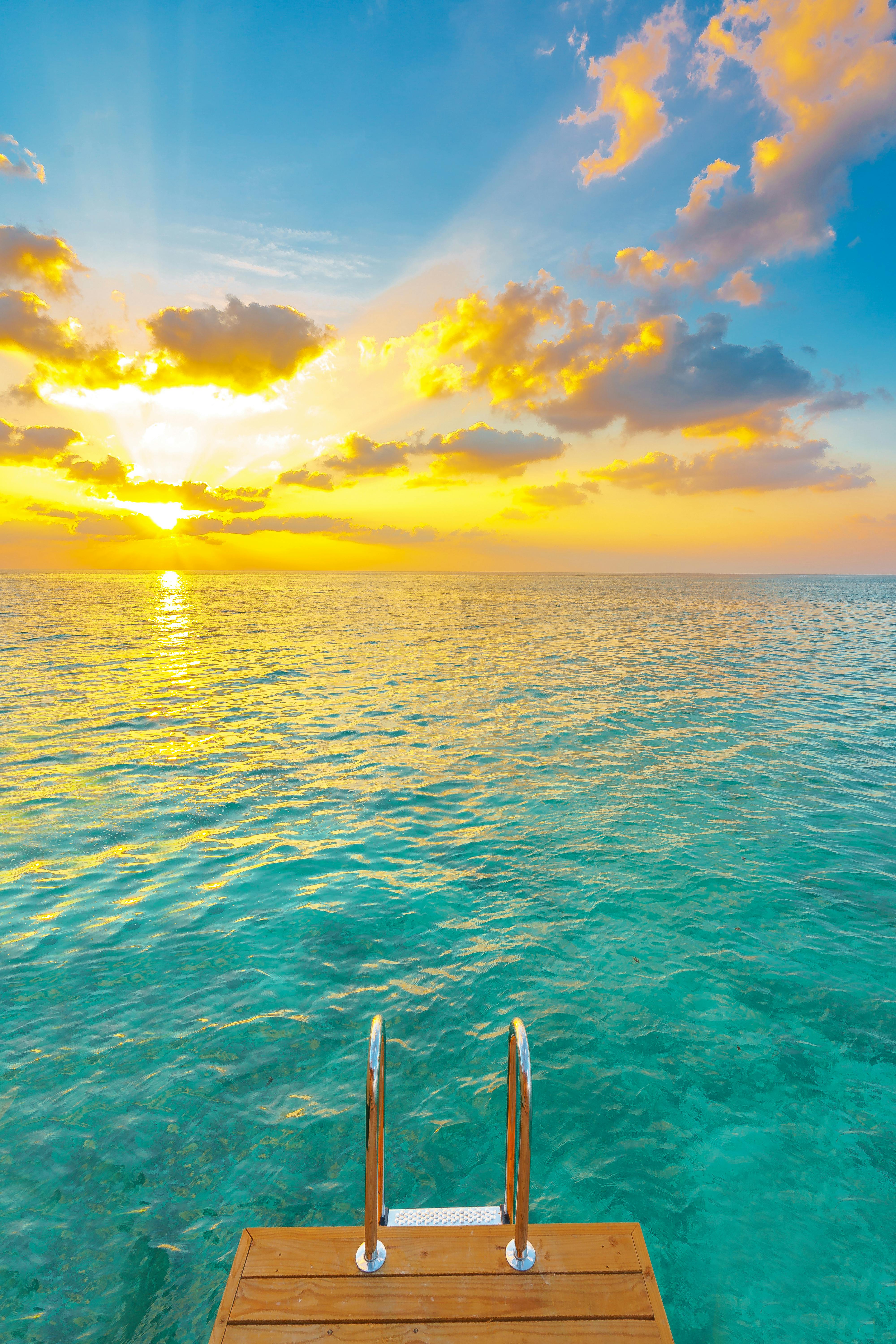 Prescription Goggle Inserts - Serene tropical sunrise over clear ocean waters with a wooden platform.