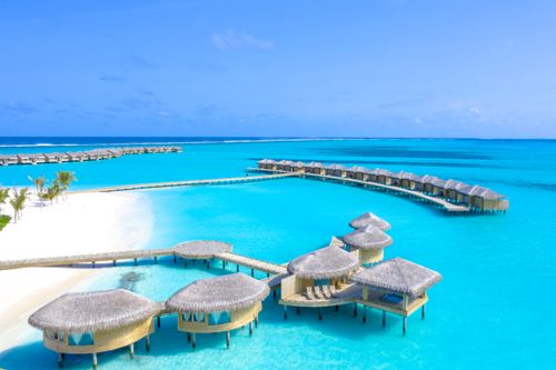 Free Stunning aerial view of tropical overwater bungalows on the clear blue waters of the Maldives. Stock Photo