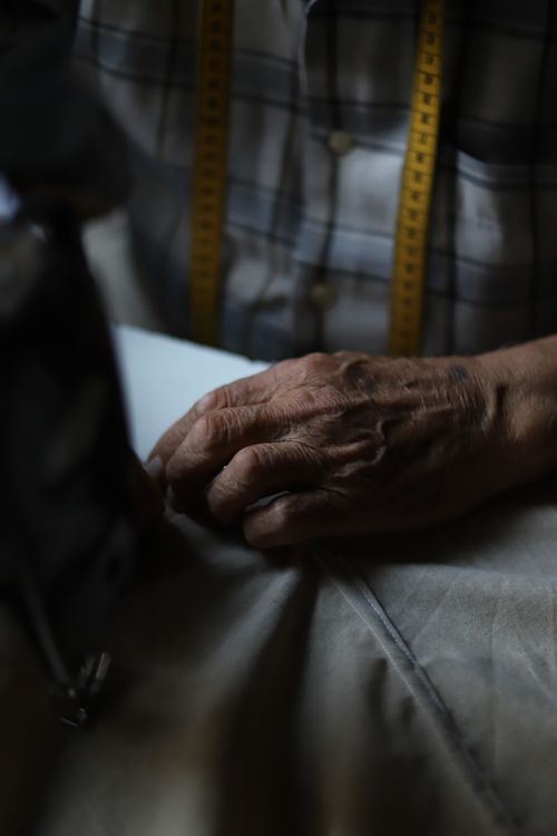 Free Detailed view of an elderly tailor's hands working fabric. Stock Photo