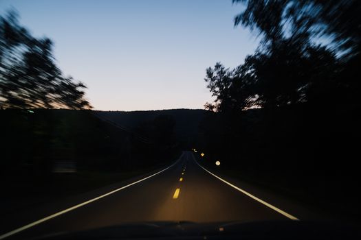 Experience the serene beauty of a drive on a rural road at twilight.