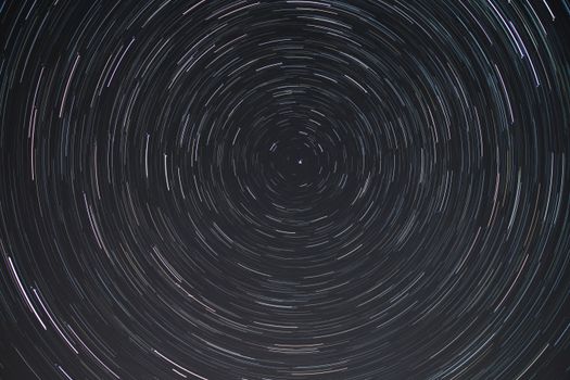 Mesmerizing long-exposure shot of star trails forming circular patterns in the night sky.