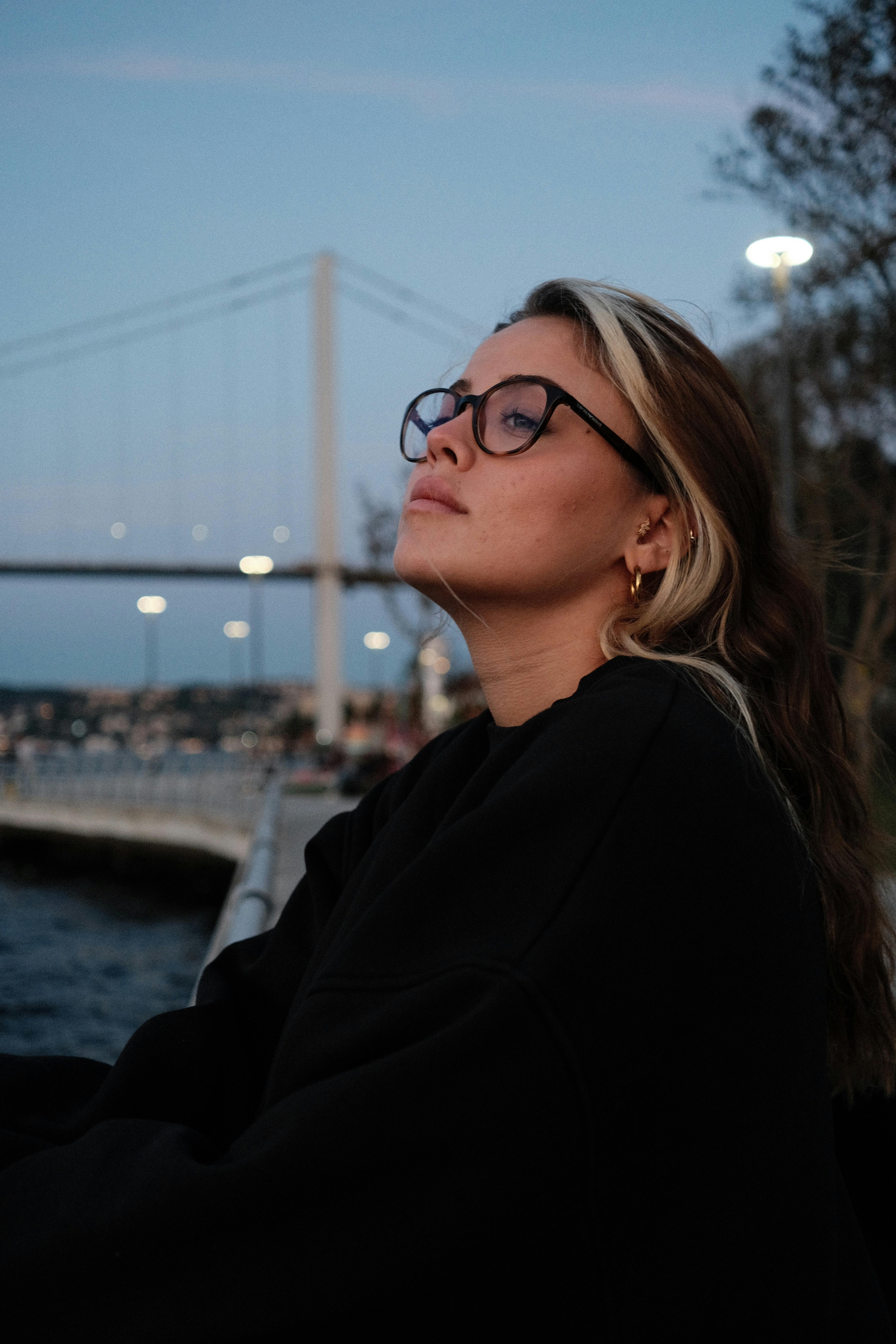 contemplative woman by river at twilight