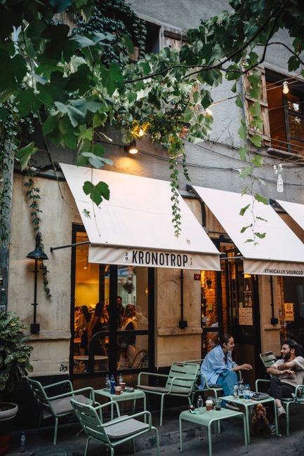 Charming outdoor café with people enjoying evening in bustling urban setting.
