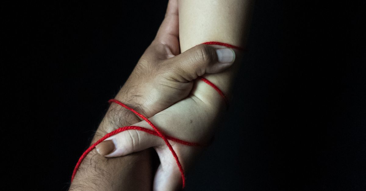Intertwined Hands with Red String Symbolism · Free Stock Photo