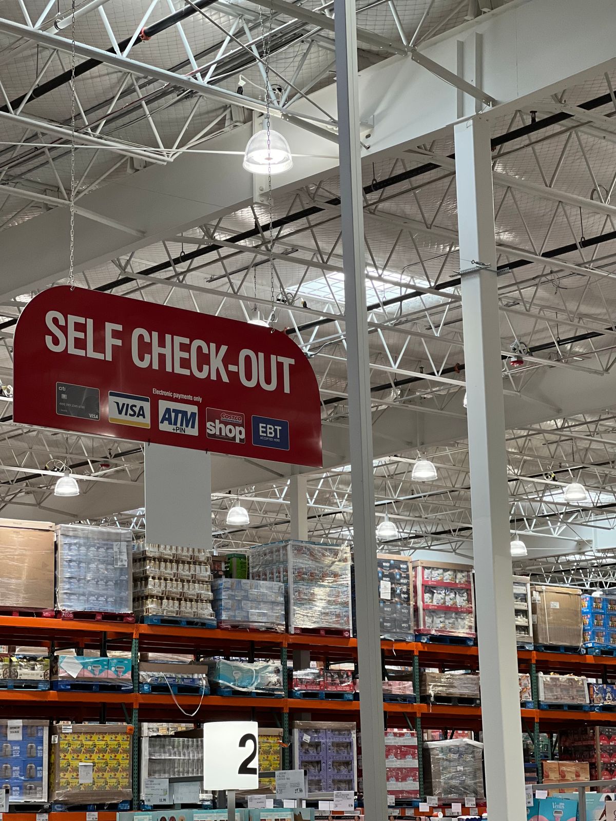 A bank of self-checkout stations with payment terminals in a large store