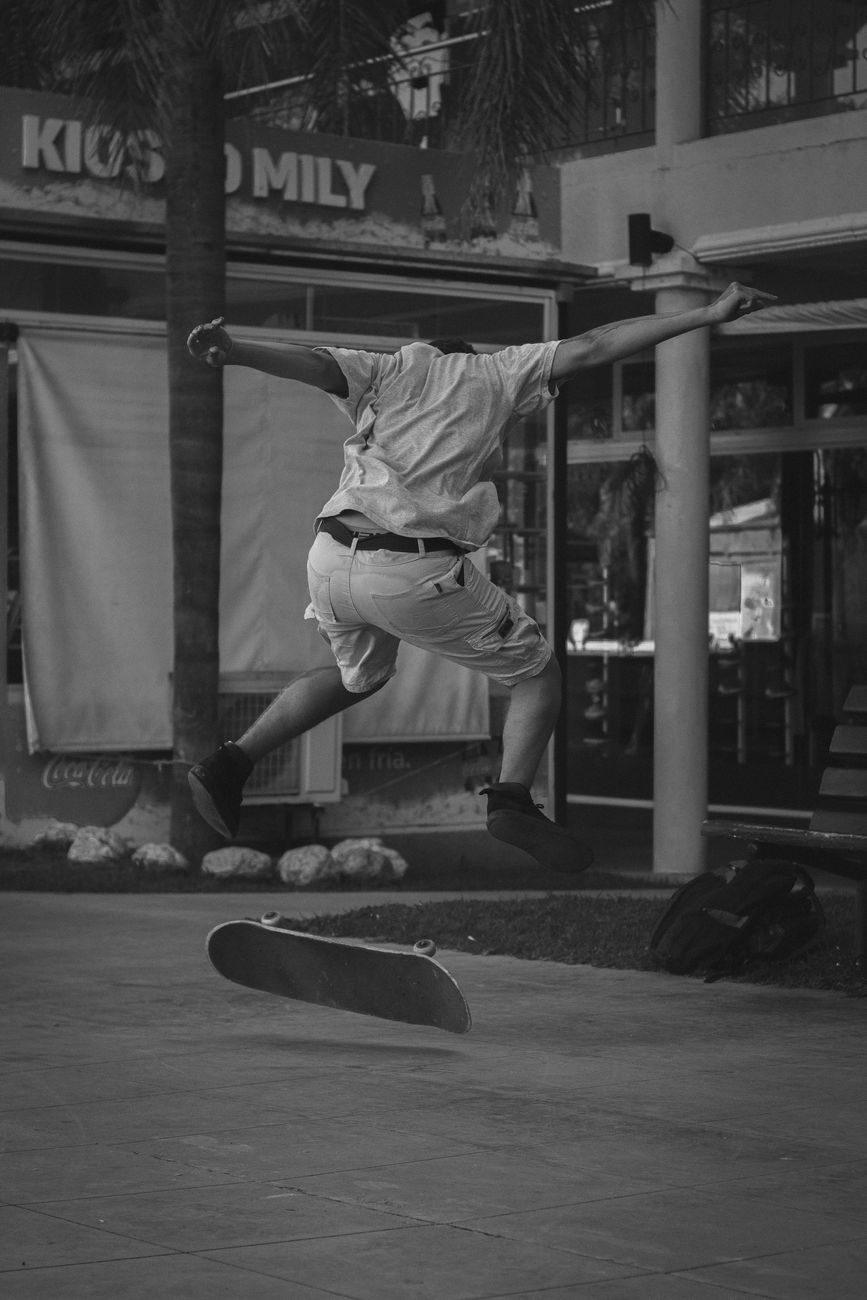 A dynamic black and white photo capturing a skateboarder mid-trick in an urban setting.. dynamic, black, white
