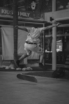 A dynamic black and white photo capturing a skateboarder mid-trick in an urban setting.. dynamic, black, white