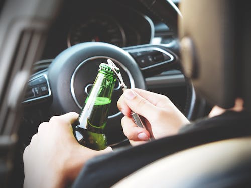 Person Opening Bottle on Car