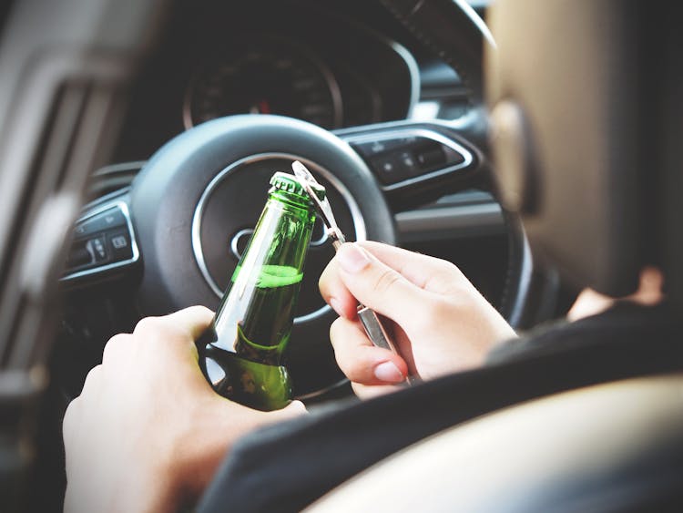 Person Opening Bottle On Car