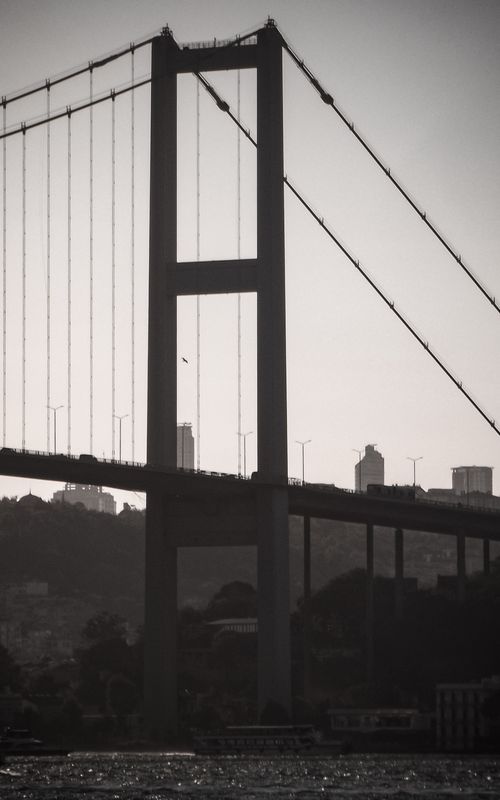 Free Dramatic silhouette of the Bosphorus Bridge against a twilight sky with cityscape background. Stock Photo