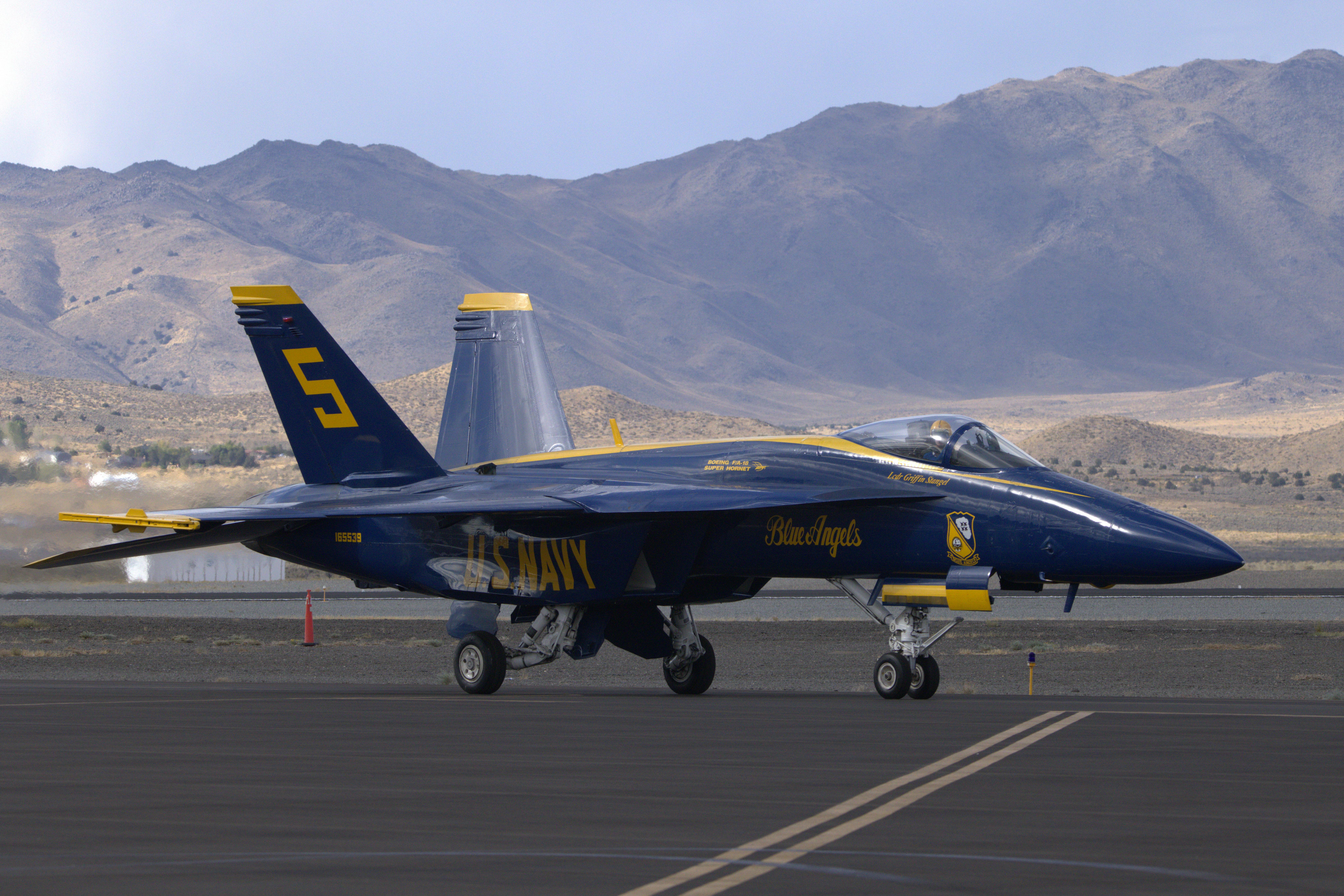 Blue Angels F/A-18 Hornet jet from US Navy on runway in desert landscape.