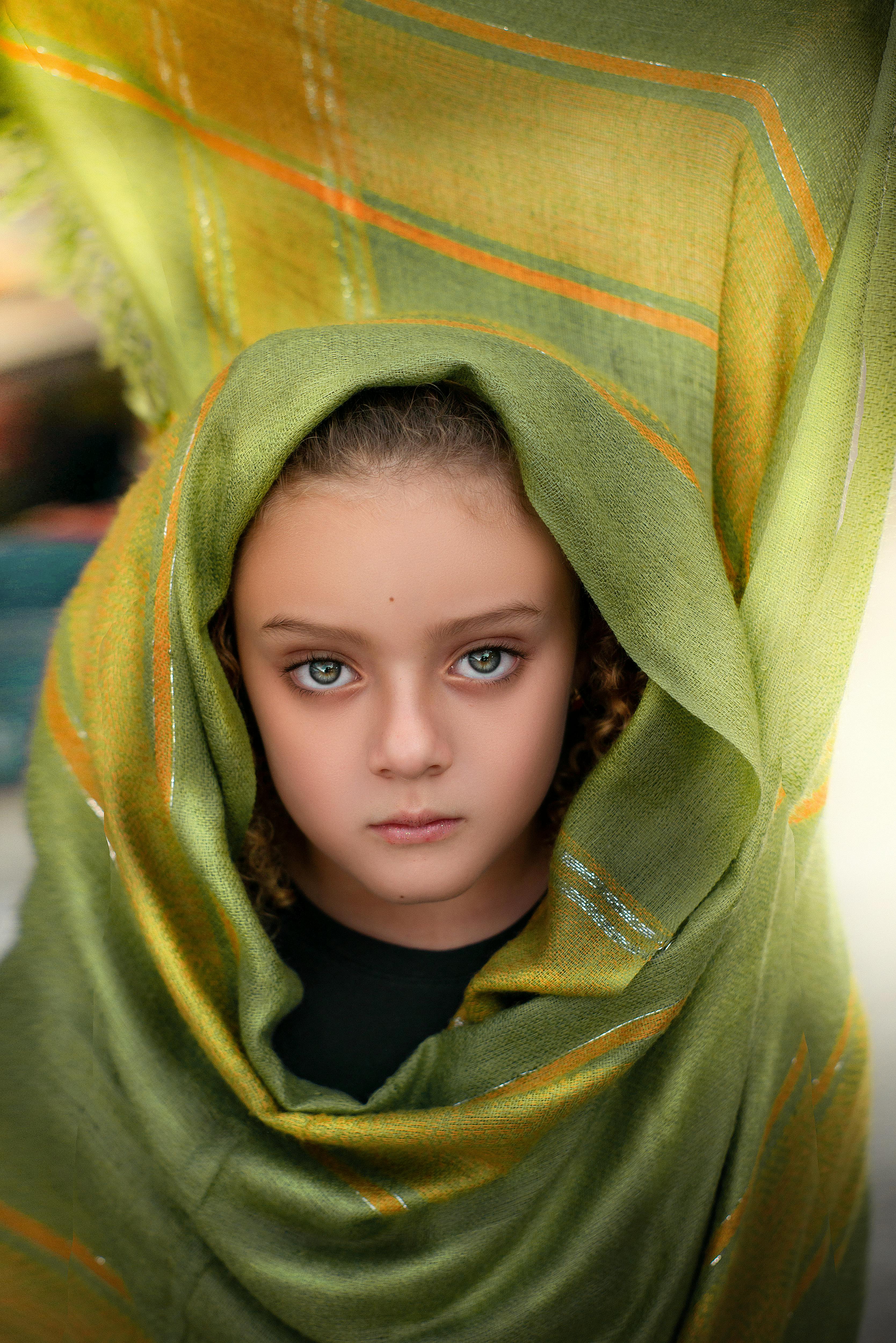 portrait of a child wrapped in green fabric