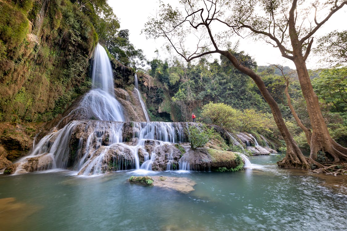 Person Standing Near Waterfalls