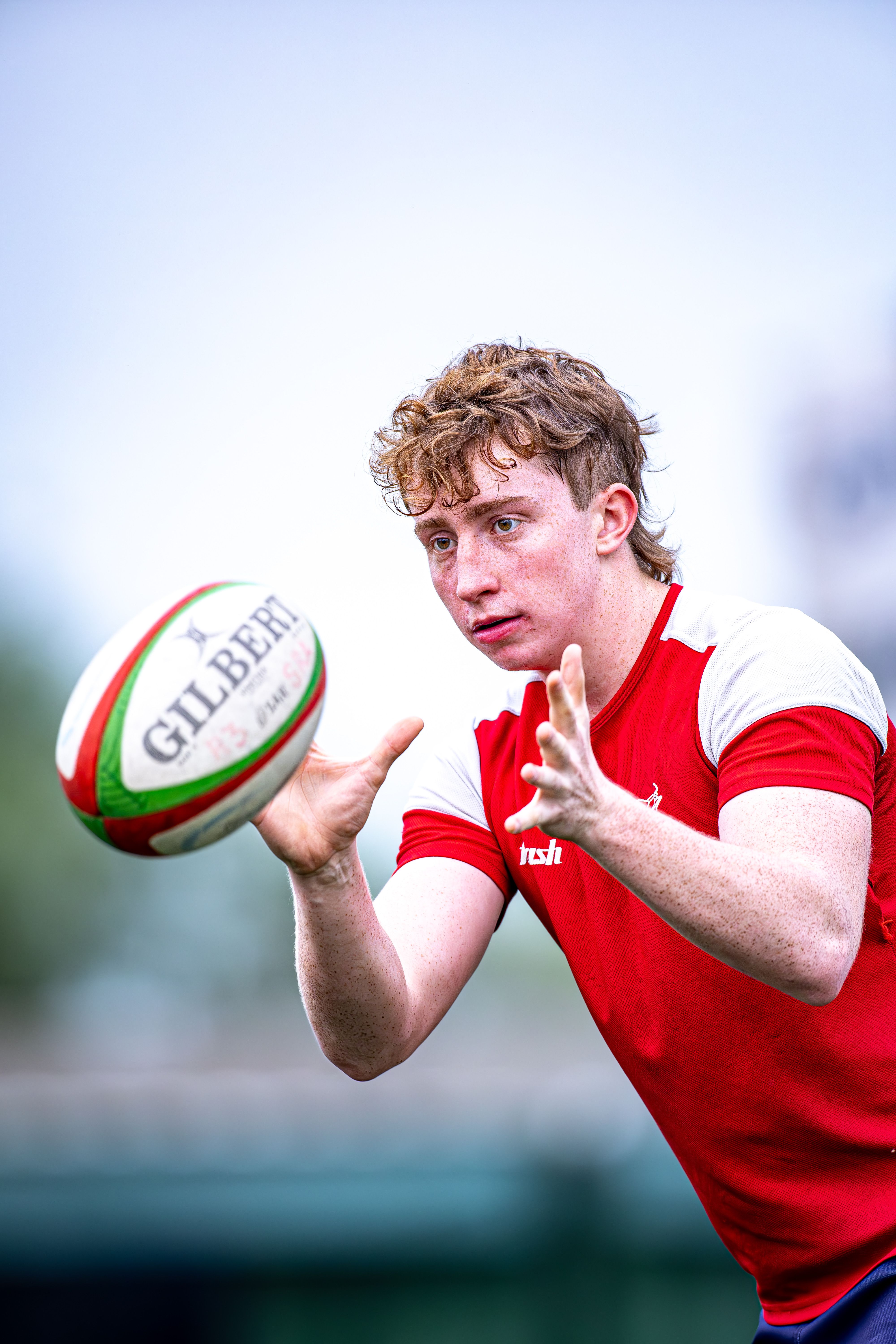 Dynamic shot of a young boy catching a rugby ball during an outdoor game.