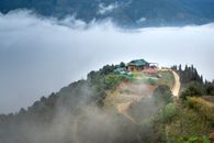 一座宁静的山屋，四周雾气缭绕，绿意葱茏，是一处静谧的度假胜地