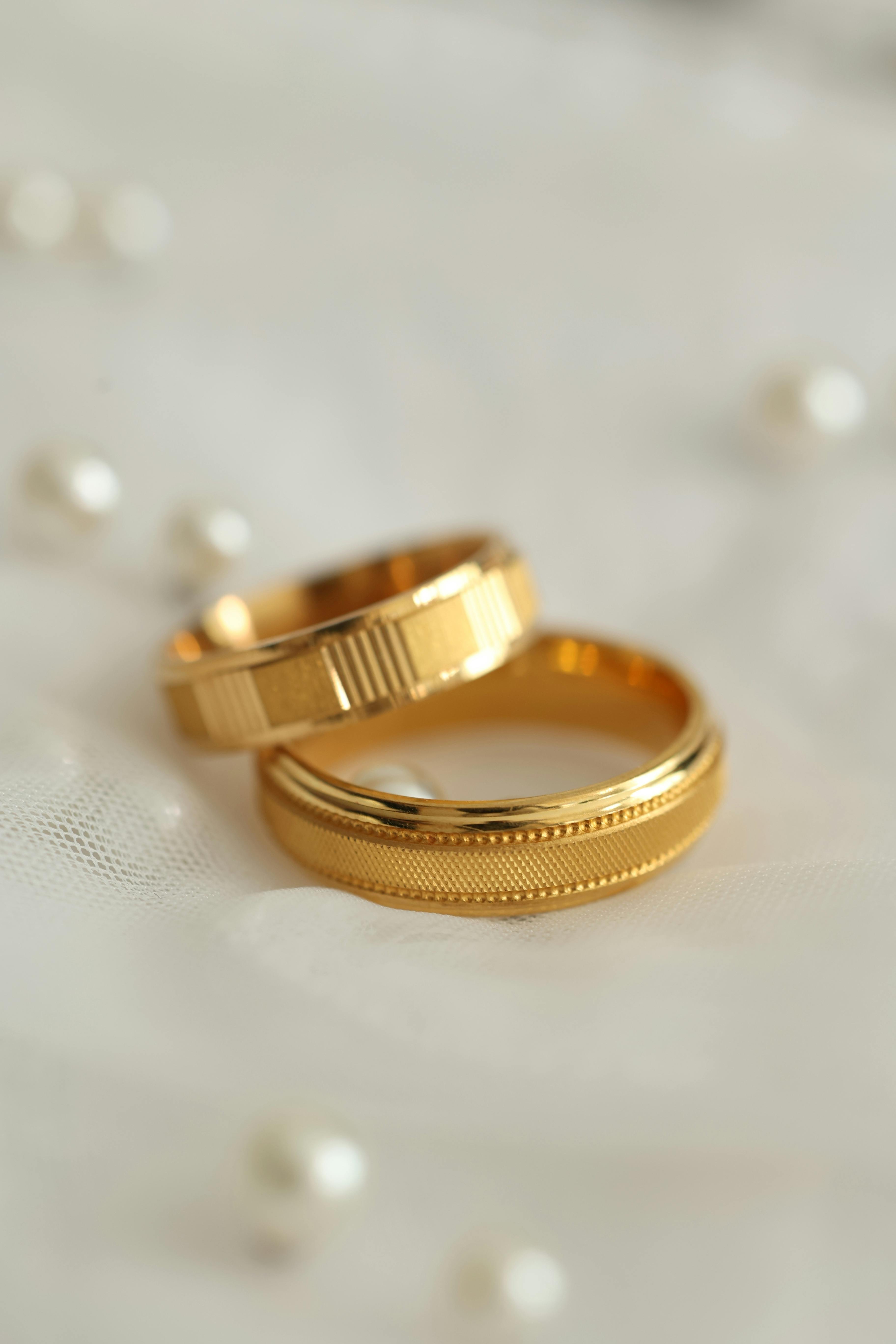 elegant gold wedding rings on white fabric