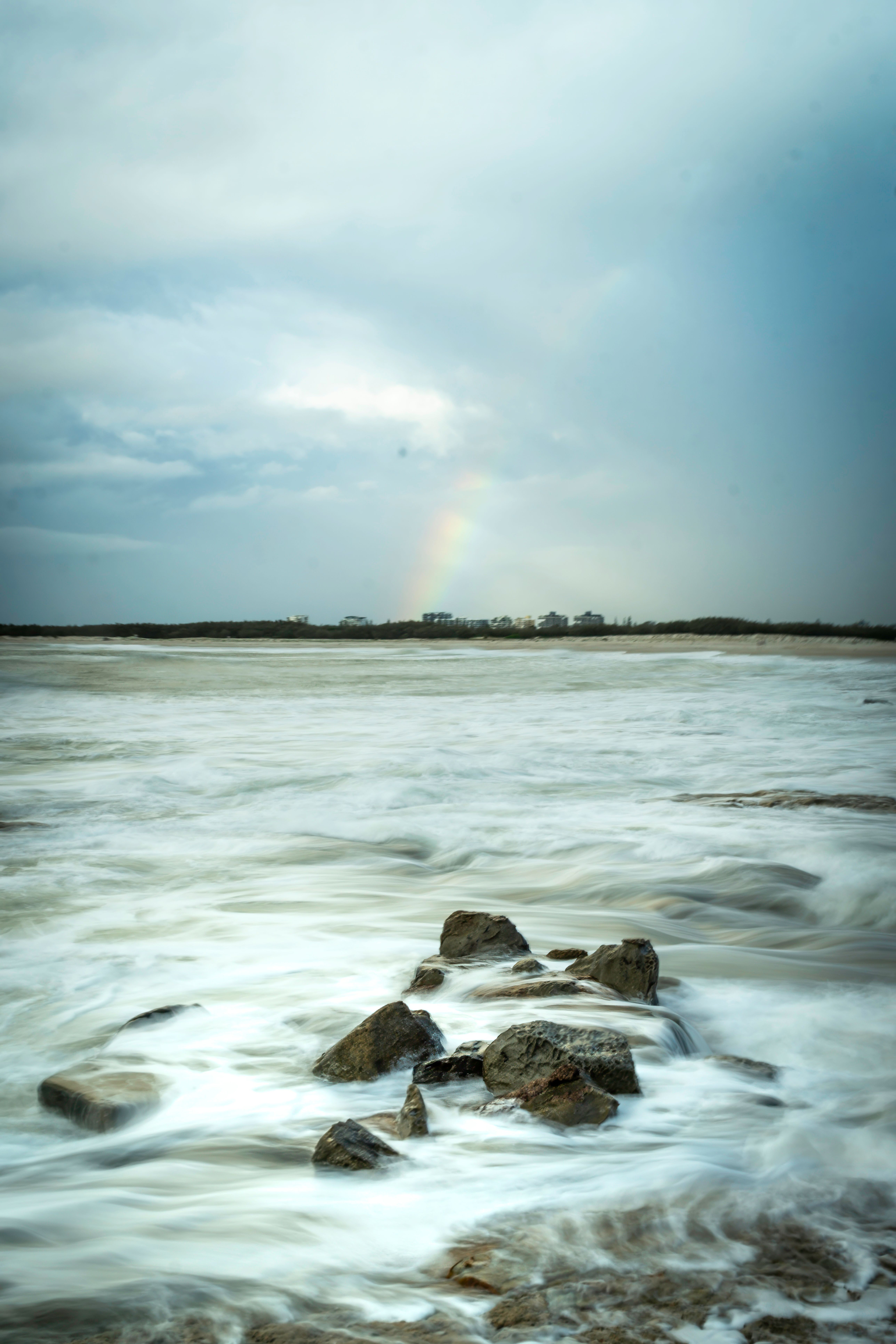 Serene Seascape with Rainbow and Rocks · Free Stock Photo