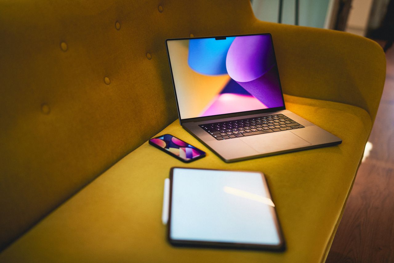 a cozy home office setting with a laptop smartphone and tablet on a ye
