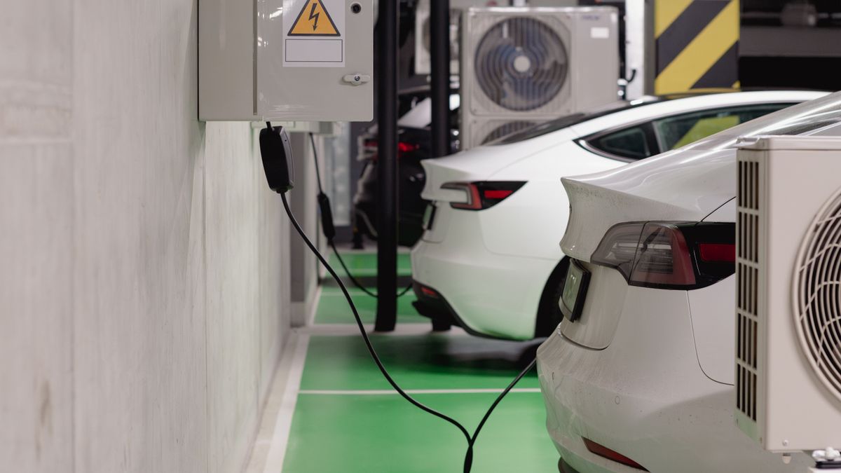 Electric vehicles charging at an indoor station in a modern underground garage.