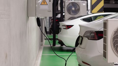 Electric vehicles charging at an indoor station in a modern underground garage.
