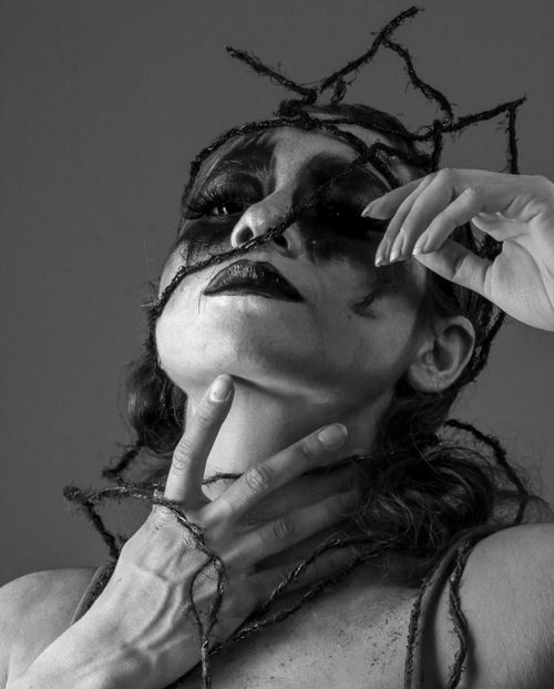 Free A striking black and white portrait of a woman with dramatic makeup and tangled cords for an intense effect. Stock Photo