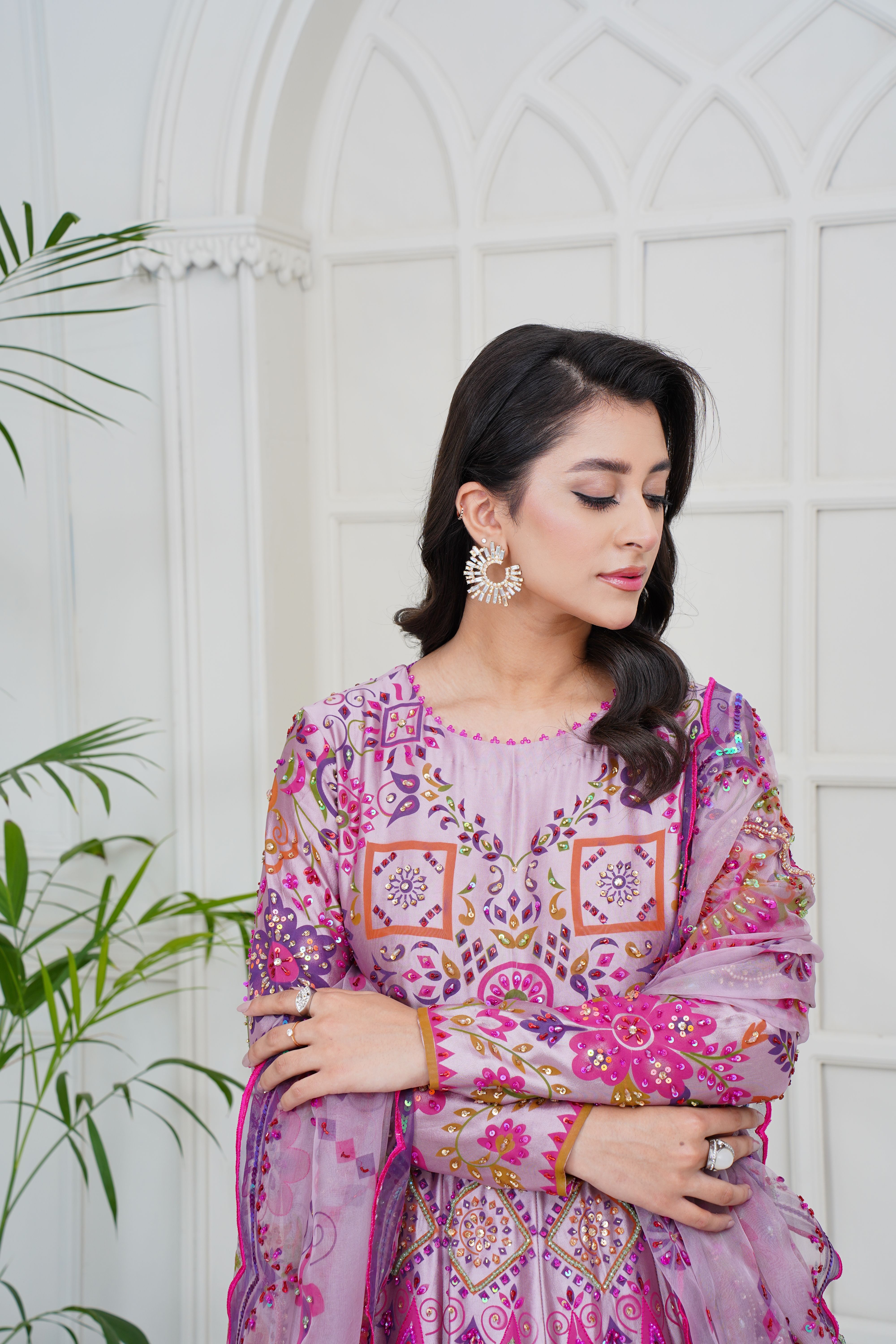 A fashionable portrait of a model in an intricately designed Eastern dress indoors.