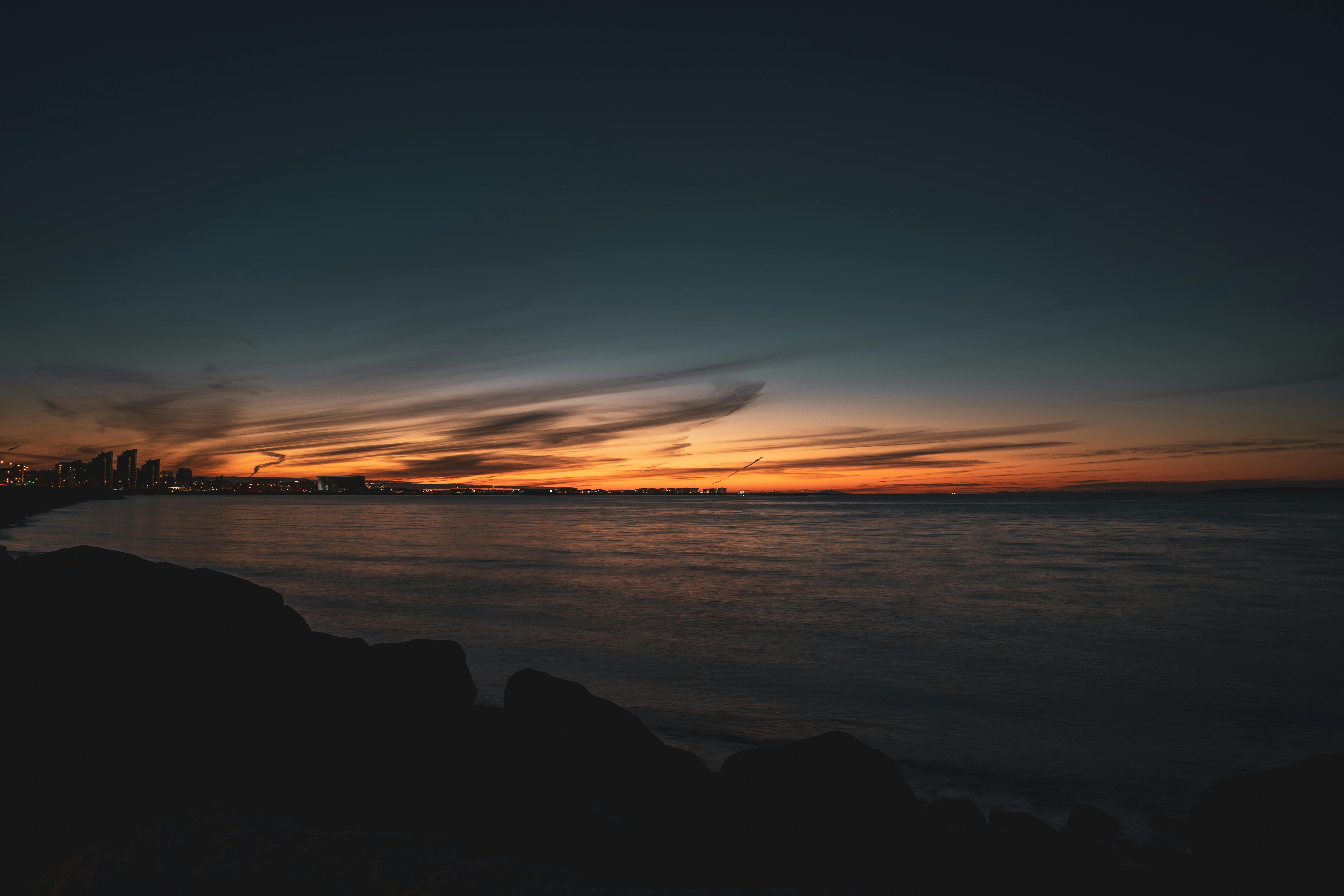 serene coastal sunset over the ocean with cityscape