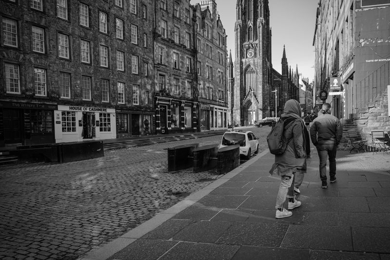 Black and white view of Edinburgh street with people walking towards St. Giles' Cathedral.
