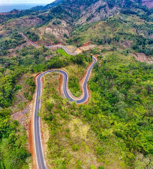 Free Aerial view of a winding mountain road in lush West Java landscapes, showcasing natural beauty. Stock Photo