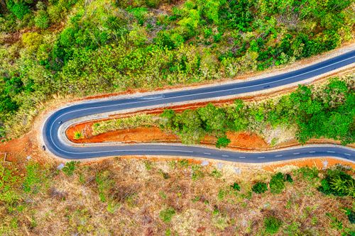 Free Stunning aerial shot of a winding road amidst lush greenery in West Java, Indonesia. Stock Photo