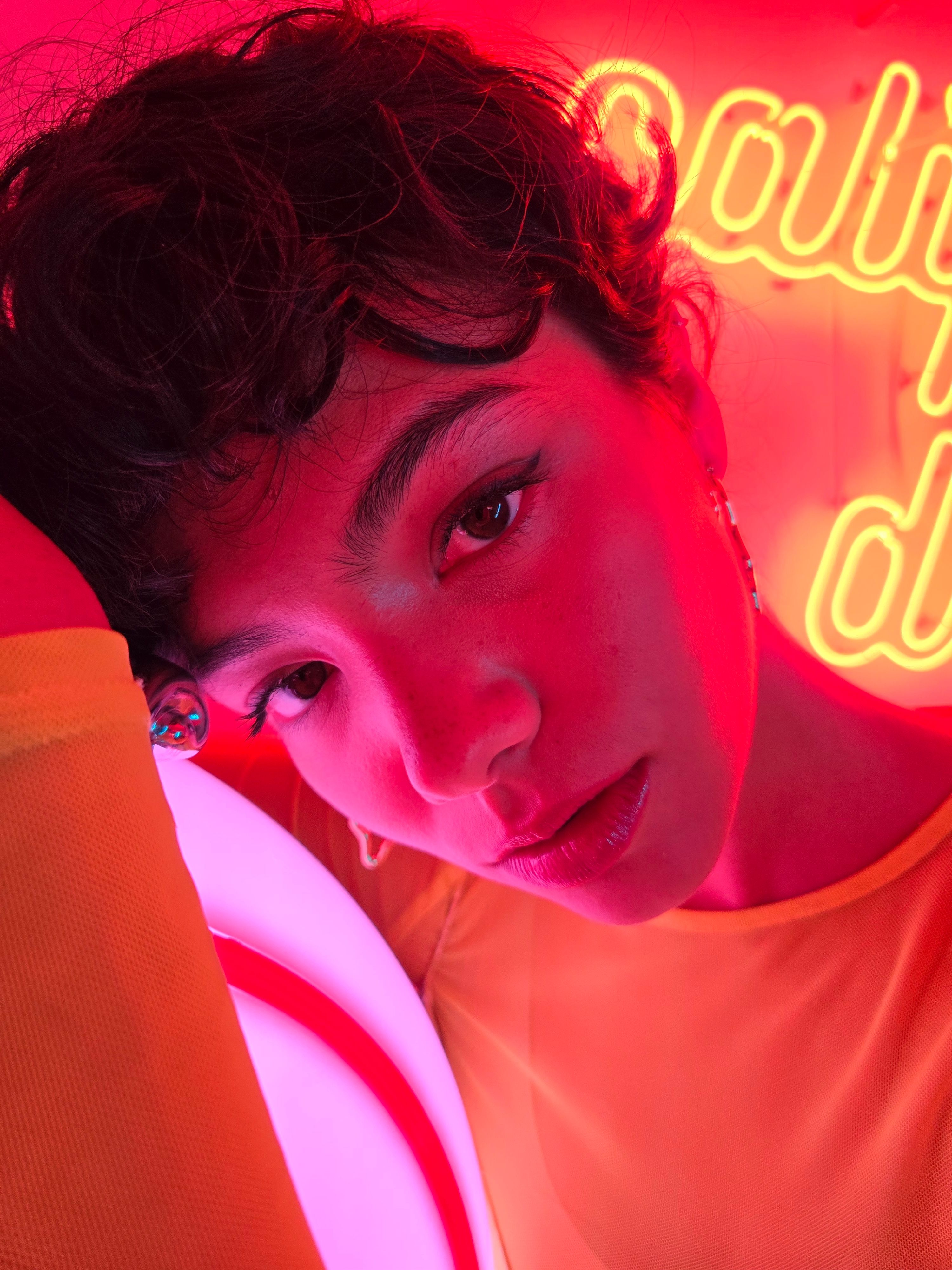 Close-up portrait of a person under vivid red and pink neon light, stylish atmosphere.