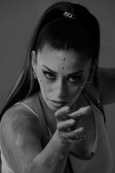 Striking black and white portrait of a woman with artistic face paint and intense expression.