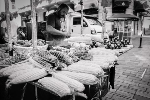 Captivating black and white photo of a street vendor selling corn in Istanbul.