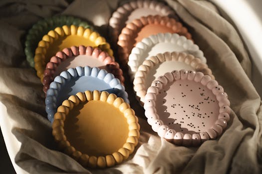 A set of colorful ceramic plates arranged aesthetically on fabric, showcasing unique designs.