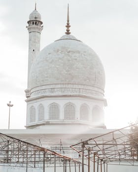 A beautiful mosque with a striking dome and minaret under a bright, clear sky.