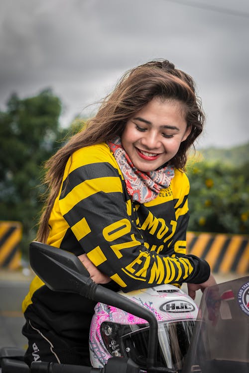A Smiling Woman Riding A Motorcycle