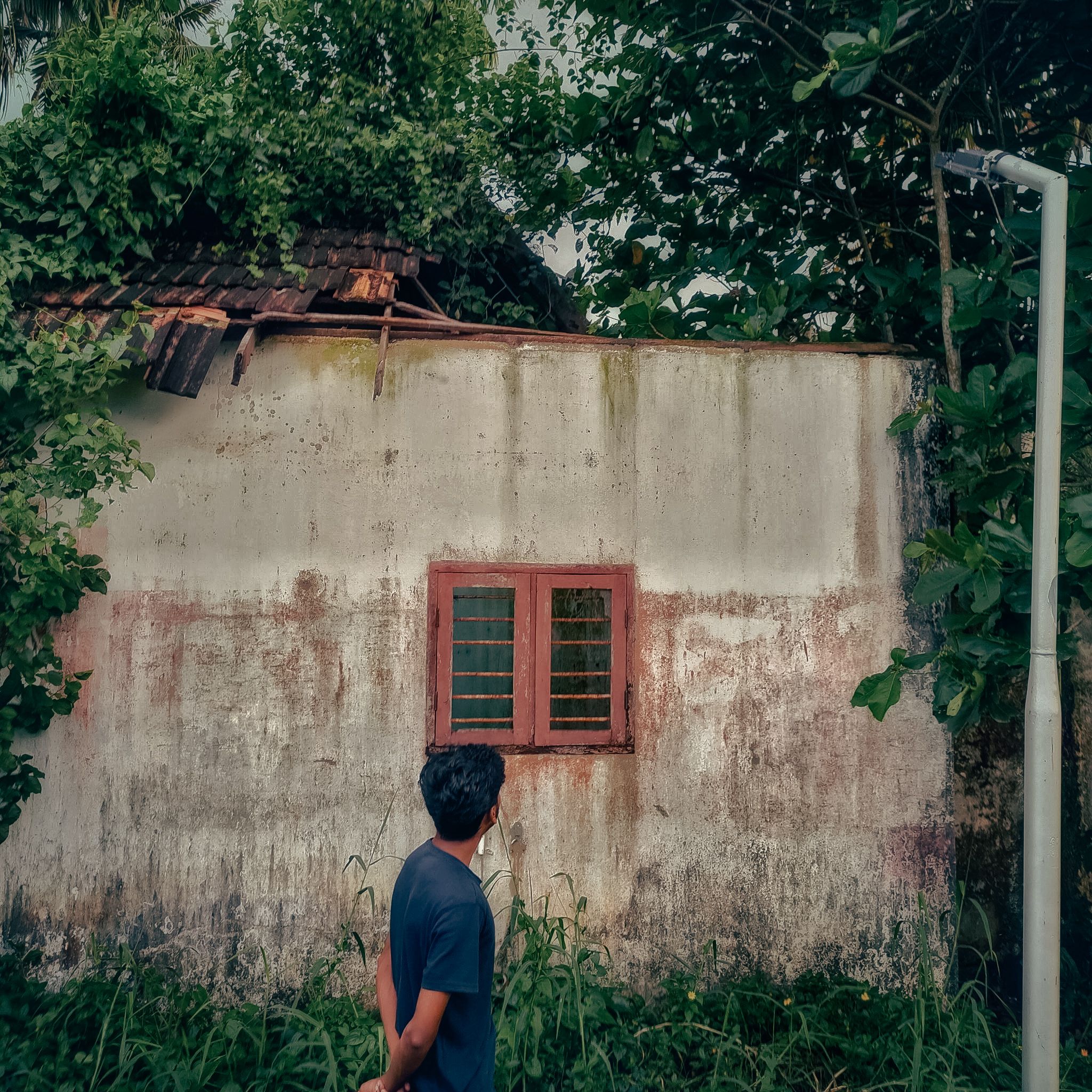 Man Observing Rustic Wall and Window Exterior · Free Stock Photo