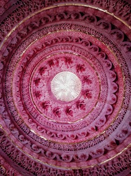 充满活力的粉红色圆形天花板，饰有复杂的几何图案和华丽纹样，营造出艺术装饰风格