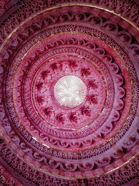 A vibrant pink circular ceiling with intricate geometric and ornate patterns for artistic decor.