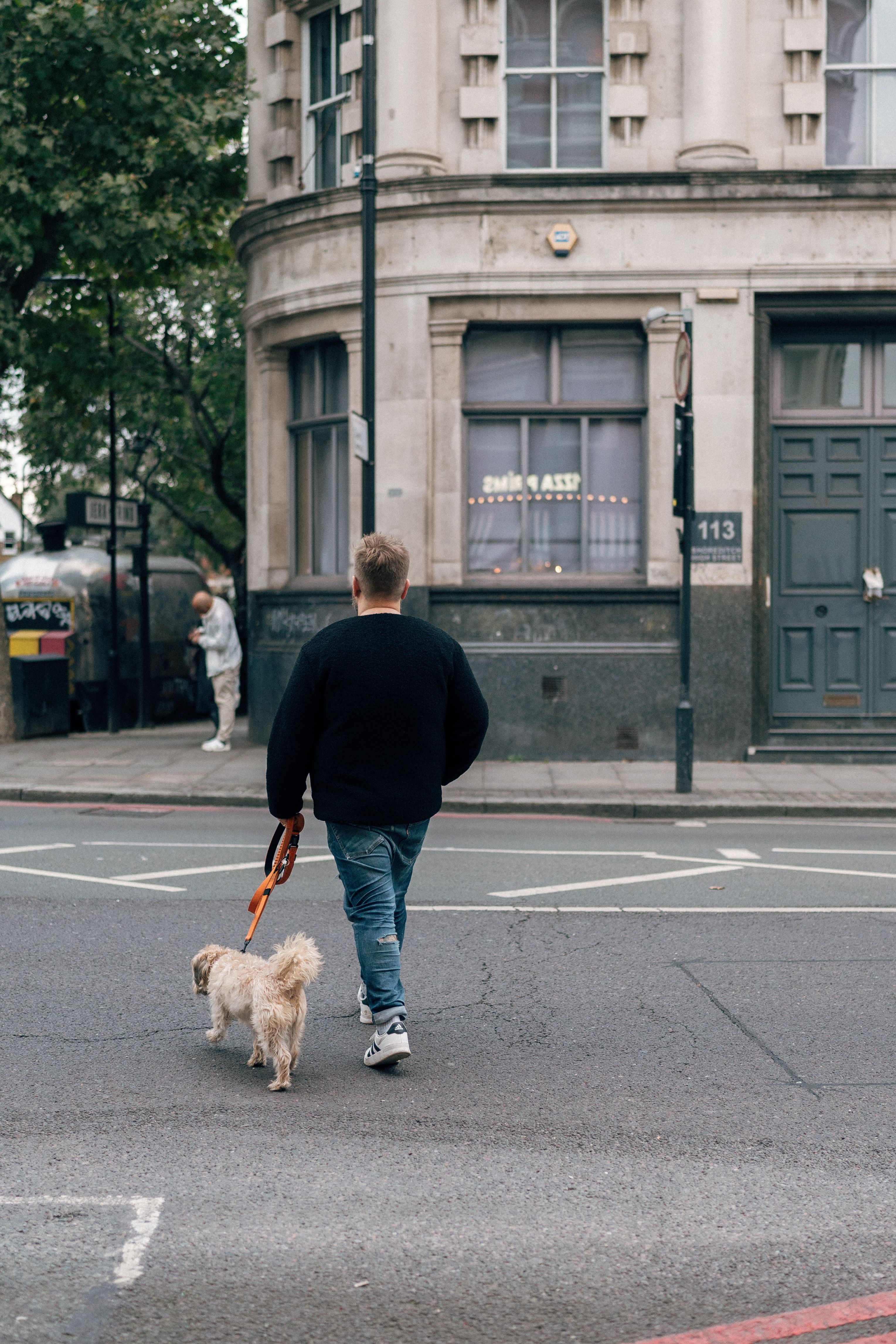 A man walking his dog along a busy city street