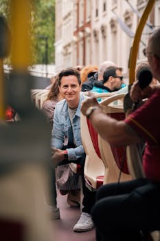 A smiling man enjoys a guided open-top bus tour in the city.