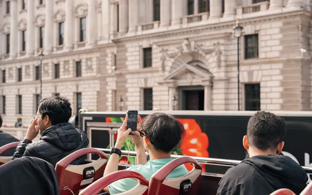 Des visiteurs dans un bus touristique à impériale découvert